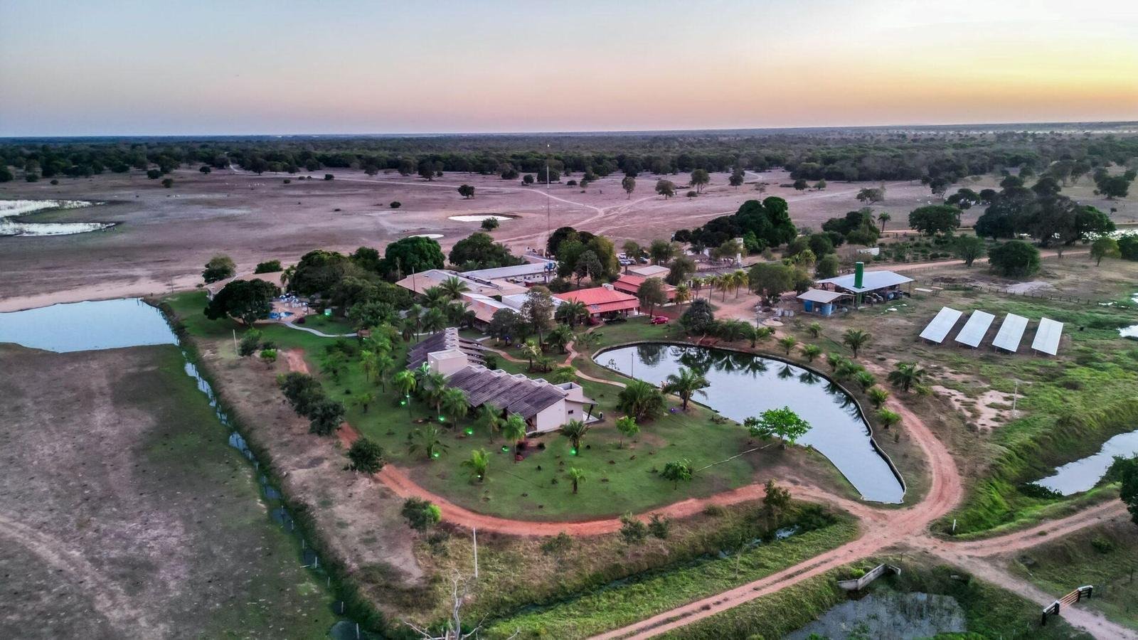 Aerial view of Pousada Piuval's buildings, grounds and lakes at dusk