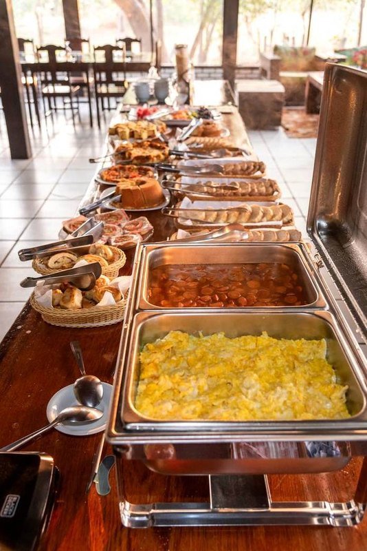 Breakfast buffet with hot dishes in chafing dishes and baskets of bread