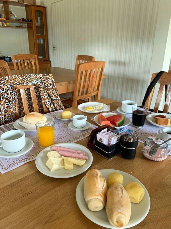 Breakfast table with bread, cold cuts, fruit, juice and coffee