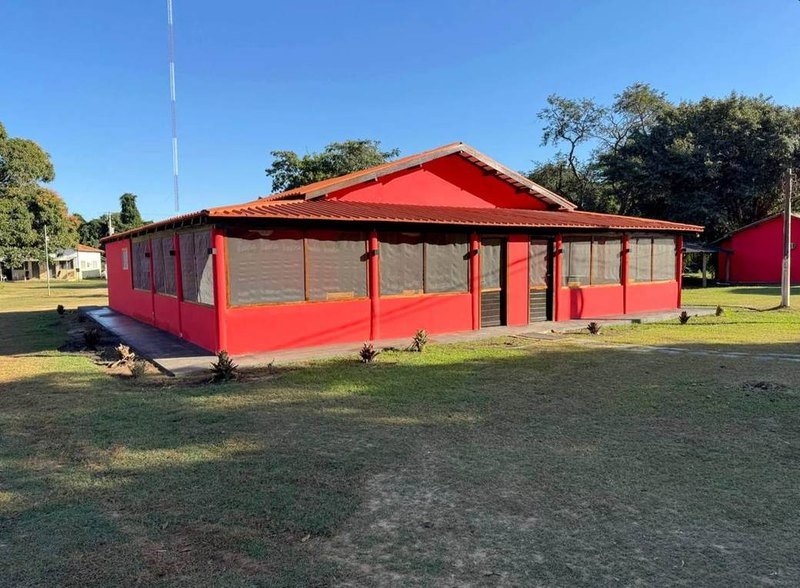 Exterior of the Suíte Imperial, a red building with a tiled roof and a screened veranda, surrounded by lawn