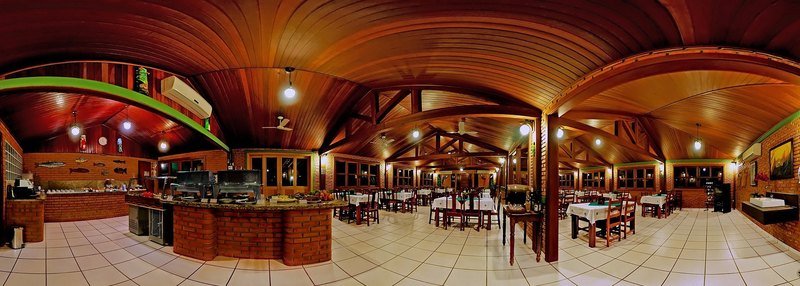 Panoramic view of the restaurant, with a curved wooden ceiling, a brick buffet counter and tables with white tablecloths