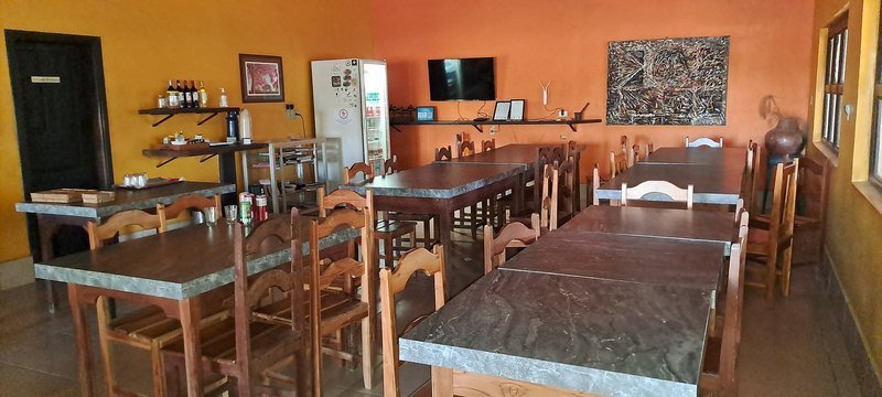 Dining room with orange and yellow walls and wooden tables and chairs