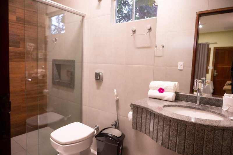 Suíte Luxo bathroom with a glass shower and a granite sink