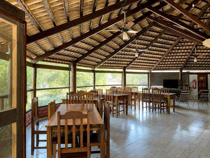 The lodge dining room with long wooden tables and chairs under a tiled wooden roof